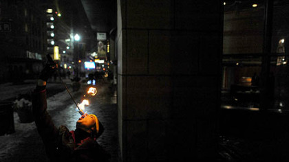 Fire-eater Kristin Ward performs for the crowd Monday along Penn Avenue.