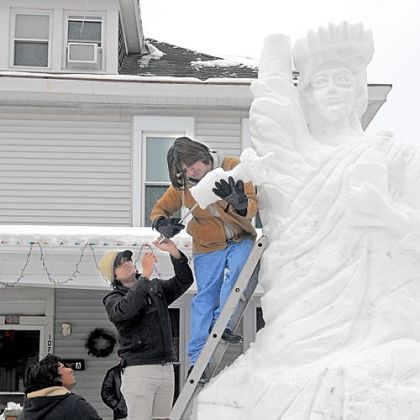 From top, Minhas Hameed, Umair Akhlas and Mohsin Hameed top off a 15-foot-tall Statue of Liberty made of snow in the front yard of their home Monday in the 1100 block of Fourth Avenue in Beaver. The families, who are Christians, are recent arrivals in the U.S., leaving their native Pakistan due to religious violence.