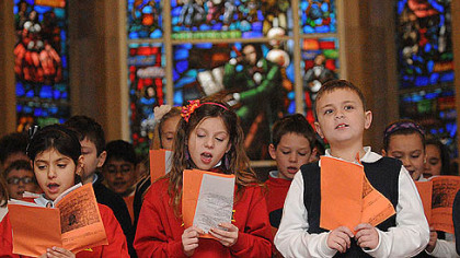 Leeann Parsi, Carlee Fettis, and Mickey Gallagher, a third-graders at St. Raphael in Morningside, sing at the memorial service honoring the 149th Anniversary of Stephen Foster's death.