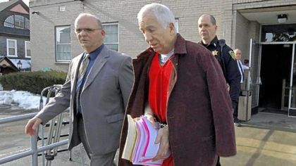 Former Penn State University assistant football coach Jerry Sandusky, center, leaves the Centre County Courthouse on Thursday, escorted by Centre County Sheriff Denny Nau, left, after attending a post-sentence motion hearing in Bellefonte.