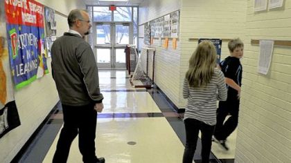 Frank Cichra, a retired Pennsylvania trooper, patrols the hallway at Summit Elementary School, part of the Butler Area School District. Although he is armed, he does not keep the gun in plain sight.
