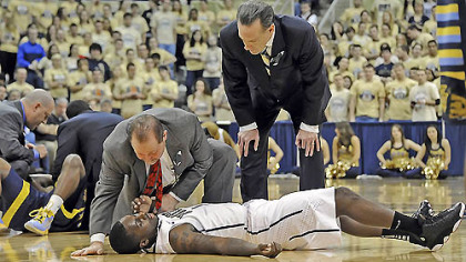 Pitt's Tray Woodall is attended to by trainer Tony Salesi and head coach Jamie Dixon after colliding with Marquette's Derrick Wilson in the first half this afternoon at the Petersen Events Center. Woodall left the game with a concussion.




