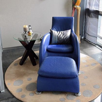 A blue chair and ottoman provide a small focal point in the living room.
