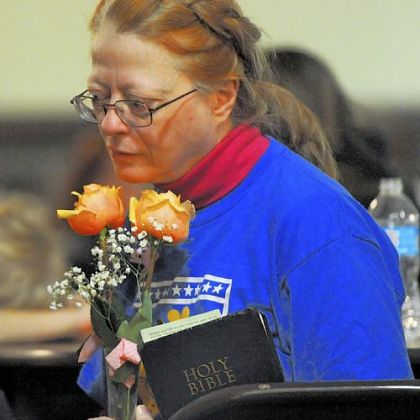 Maryellen Deckard from Action United holds Ka'Sandra Wade's Bible and flowers that were presented to Ms. Wade's mother, Sharon Jordan, at the vigil on Saturday.
