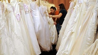 Stephanie Williams, left, and her friend and bride-to-be Amanda Clyde, both of Ellwood City, go through the racks of dresses Sunday at the Center for Building Hope charity wedding gown sale at The Fez in Aliquippa.