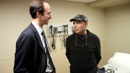 Toni Pais talks to UPMC neurosurgeon Mark Richardson during a checkup in February. Dr. Richardson has developed a treatment for Parkinson's in which surgery that once required a localized anesthetic can now be performed using a general anesthetic.