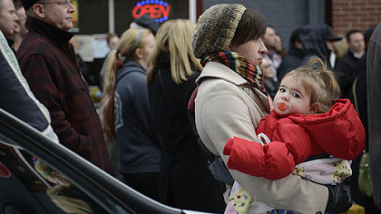 Jane Walsh and her daughter, Josephine, 19 months old, of the South Side, listen to the mayor during his press conference.

