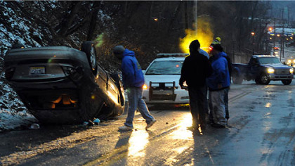 A car lies on its roof early this morning after coming down an icy Baker Street near Butler Street in Morningside.