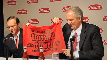 At a press conference today, Alex Behring, right, managing partner at 3G Capital was presented with a Heinz red Terrible Towel by William R. Johnson, chairman, president and CEO of Heinz.