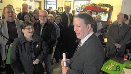 Michael Lamb laughs with supporters Wednesday after his announcement to run for mayor at Cannon Coffee in Brookline.