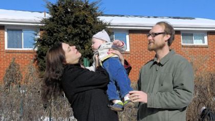 Heather Fowler and Aaron McGregor hold their son, Emmett McGregor, 12 months, in the backyard of their home.