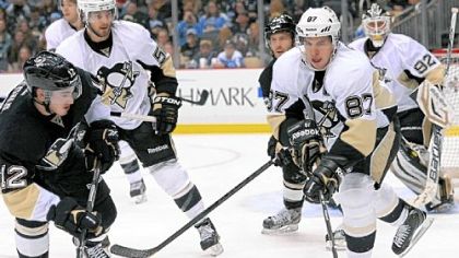 Jayson Megna, left, and Sidney Crosby, right, battle for the puck behind the net in the second period.

