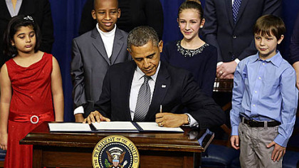 Hinna Zeejah, 8, Taejah Goode, 10, Julia Stokes, 11, and Grant Fritz, 8, who wrote letters to President Barack Obama about the school shooting in Newtown, Conn., watch as Mr. Obama signs executive orders today outlining proposals to reduce gun violence.
