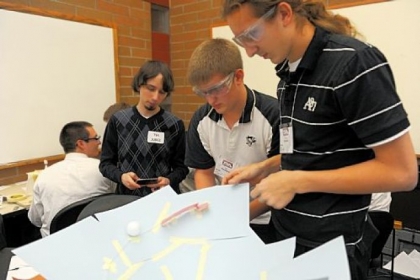 Garrett Buyan, left, a judge at Technology Student Association competition, times Kevin Brenneman, center, 18, and Austin Hartman, 17, both of Ambridge Area Senior High School, as they demonstrate the device they created to keep a golf ball in motion for exactly 10 seconds.