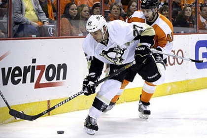 The Penguins' Craig Adams controls the puck in front of the Flyers' Andrej Meszaros.