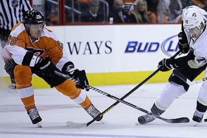 The Penguins' Evgeni Malkin tries to control the puck between Ruslan Fedotenko and Zac Rinaldo.