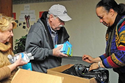 Ruth and Bob Sasser, left, from Upper St. Clair and Marva Williams from Penn Hills assemble care packages for military families in Pittsburgh at the Homewood AME Zion church in Homewood as part of the National Day of Service in honor of Rev. Martin Luther King, Jr.