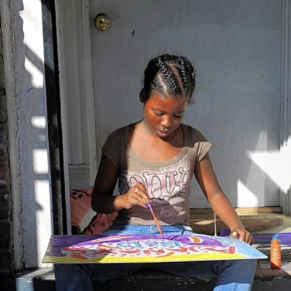 Ajanay Holly, 11, sits in a stream of light on Vanessa German's front porch on Hamilton Avenue.