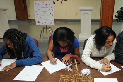 K'sandra Harding, 13, Jada Doleno, 13, Nila Andrews, 14, and Roman Burkes, 14, from the Melting Pot Ministries in the South Hills join in the National Day of Service in honor of Martin Luther King Jr. at the Homewood AME Zion church by writing letters to members of the military.
