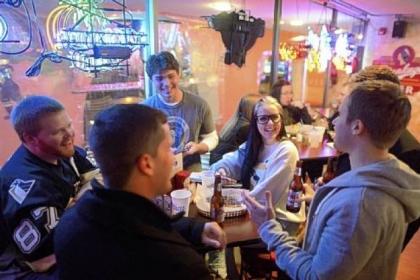 Clockwise from left, friends Justin Lysaght of Bridgeville; Nick Smith of Bridgeville; Alexis Funaro of the South Hills; Mike Ringler (obscured) of Buffalo, N.Y.; Casey Curtin of Bridgeville; and Ben McKee of Bridgeville gather at Tailgaters Bar & Grill in Pittsburgh on Wednesday before heading to the Consol Energy Center for the Penguins exhibition scrimmage.