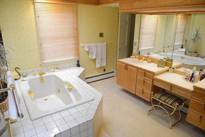 The master bathroom is roomy and light with double sinks and a makeup table combination.