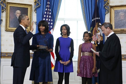 President Barack Obama, joined by First Lady Michelle Obama and daughters Malia and Sasha, is officially sworn in by Chief Justice John Roberts in the Blue Room of the White House.