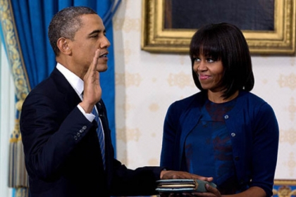 President Barack Obama is officially sworn in by Chief Justice John Roberts in the Blue Room of the White House as First Lady Michelle Obama holds the Robinson family Bible.