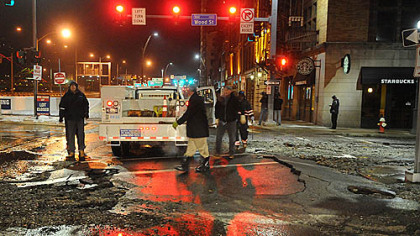 The broken surface of Fort Pitt Boulevard as crews work to shut off the flow.