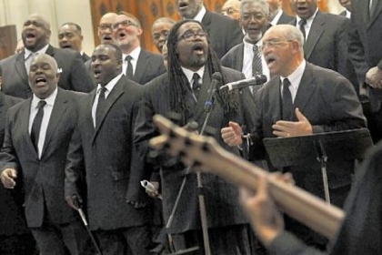 Ken Fair, right, sings with DeCarlo Gilliard, center, as the Rodman Street Missionary Baptist Church men's choir sings "God Will Deliver On Time" at the start of "A Celebration of the Life and Witness of the Rev. Dr. Martin Luther King, Jr." on Sunday at the East Liberty Presbyterian Church.