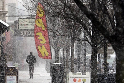 A man walks along Forbes Avenue in Squirrel Hill during Monday's snowfall.