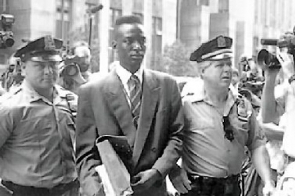 Defendant Yusef Salaam walks into courthouse flanked by police officers in "The Central Park Five."