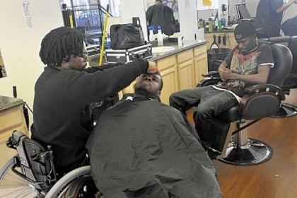 Francis Anim, of Crafton, right, waited for his friend, Adenan Ibrahim, to get his hair cut by Paul Perminter in the Barber School of Pittsburgh on Steuben Street in the West End.