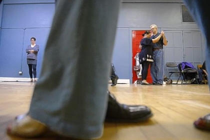 Janine Hauck of Mt. Lebanon, at left, waits for instruction while Bea Herdon of the Hill District and Michael Young of Oakland dance together Jan. 13 during Tango 101 at the Wilkins School Community Center in Regent Square.