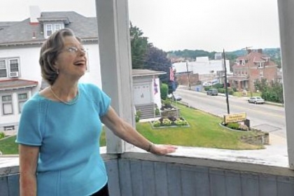 Kitty Martin, the granddaughter of William Wigman, who built the Queen Anne house at 1425 Brownsville Road in Carrick, examines the workmanship of the second floor balcony off a bedroom.