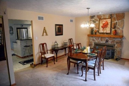 The dining room features a stone fireplace.
