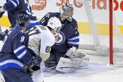 The Penguins' Sidney Crosby scores his second goal against Winnipeg Jets' goaltender Ondrej Pavelec during the first period in Winnipeg, Manitoba