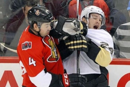 The Ottawa Senators' Chris Phillips, left, hits Penguins winger Matt Cooke in the second period.