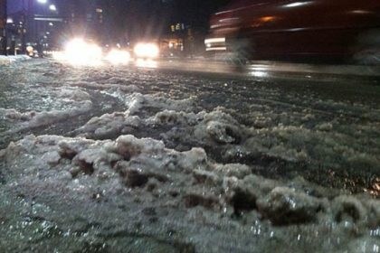 Ice and slush along Forbes Avenue in Oakland as traffic moves along the street.