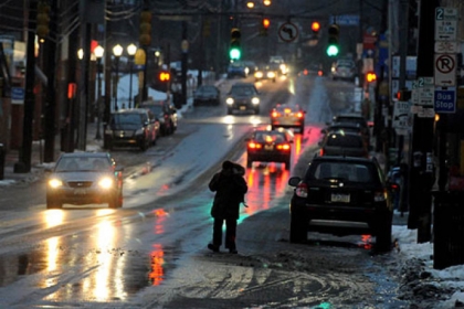 A man walks  along Murray Avenue in Squirrel Hill this morning while avoiding the slush and the slick sidewalk.
