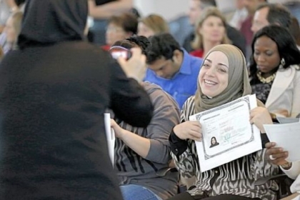 Miriam Bilaih shows off her U.S. citizen naturalization document Monday after a naturalization ceremony in Irving, Texas.