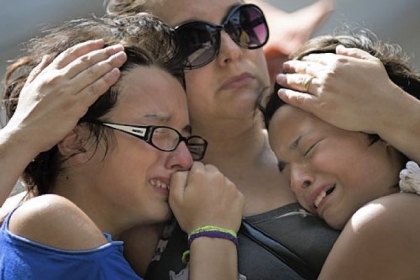 Girls cry in front of a makeshift memorial Tuesday outside the Kiss nightclub where a fire killed 234 people in Santa Maria, Brazil, early Sunday.