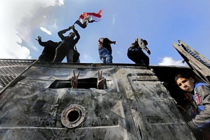 Egyptian protesters celebrate the capture of an armored vehicle Tuesday that was taken during clashes with security forces and brought to Tahrir Square in Cairo.