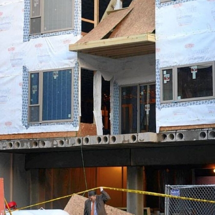 Police investigate a construction site where two workers fell three stories after the wooden landing they were on collapsed near the intersection of 49th and Harrison streets in Lawrenceville.