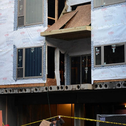 Police investigate a construction site where two workers fell three stories after the wooden landing they were on collapsed near the intersection of 49th and Harrison streets in Lawrenceville.