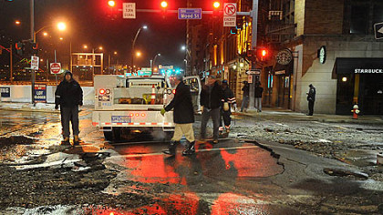 The broken surface of Fort Pitt Boulevard as crews work to shut off the flow.