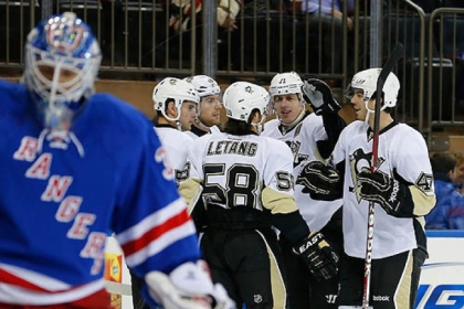 Rangers goalie Henrik Lundqvist skates away as the Penguins' Evgeni Malkin celebrates scoring a goal with teammates in the first perod.