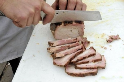 Slicing just-smoked pork loin at the smokehouse.