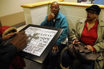 A memorial plaque is signed in memory of Isaiah Dent, 61, as 200 gathers at the community center of the Hays Manor housing development in McKees Rocks where Dent was found in his apartment beaten to death. Dent's sisters, Laverne Jackson of Wilmerding, left, and Carrol Dent of Youngstown, Ohio, watch the signing.