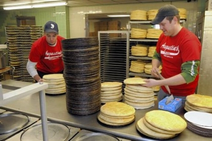 Michael Linz, left, and Al Burick stack pizza crusts at Augustine's pizza in New Castle.