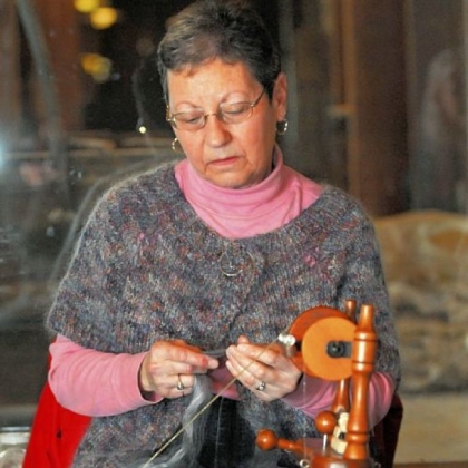 Lorraine Heasley from Hempfield, wearing her handmade sweater, spins yarn for another project.